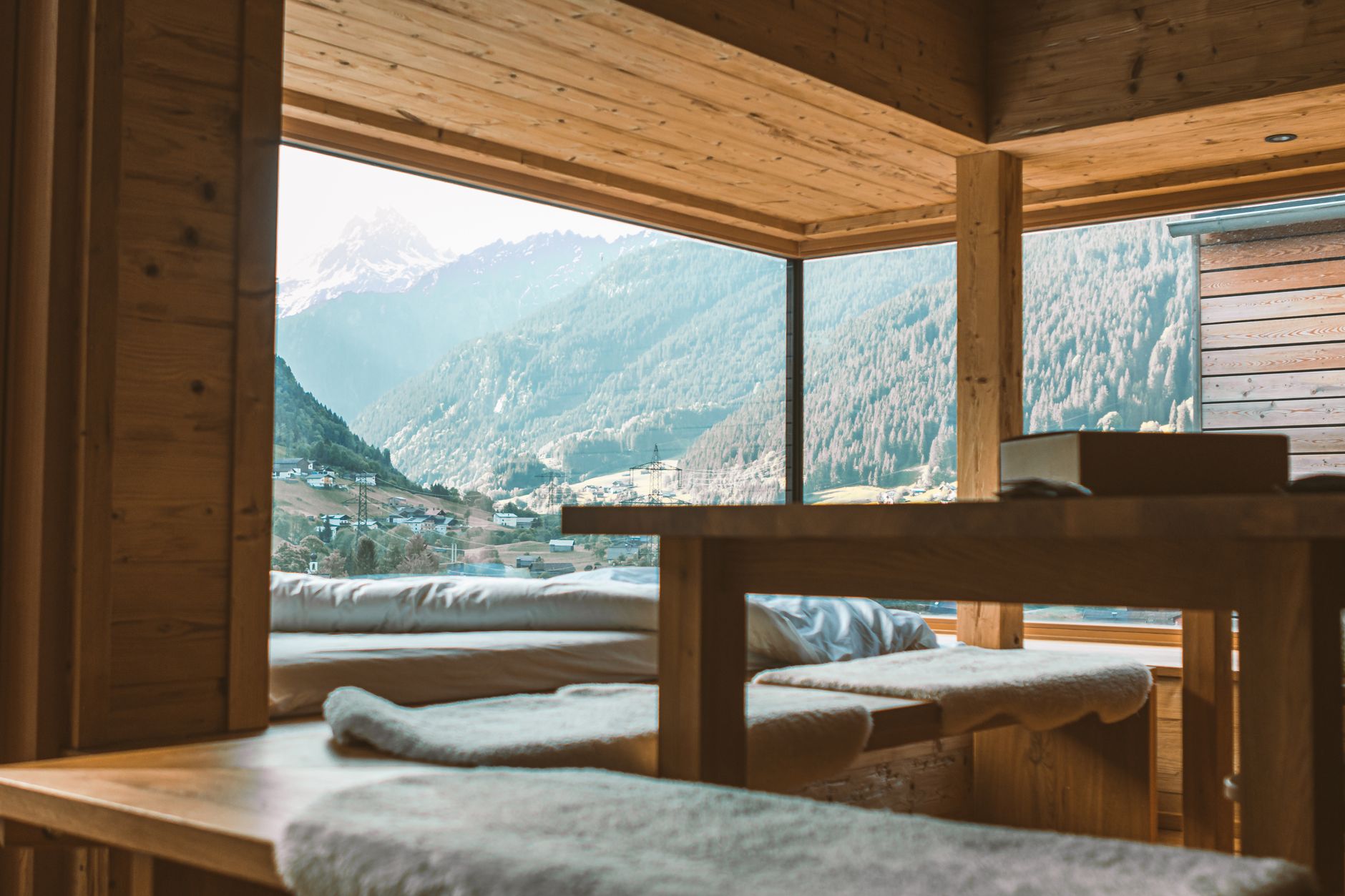 Minimalist interior of an alpine cabin looking out at mountains